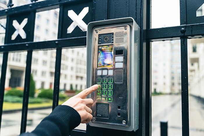Female Hand Operating Video Intercom System, Dialing Apartment Number in Urban Residential Complex